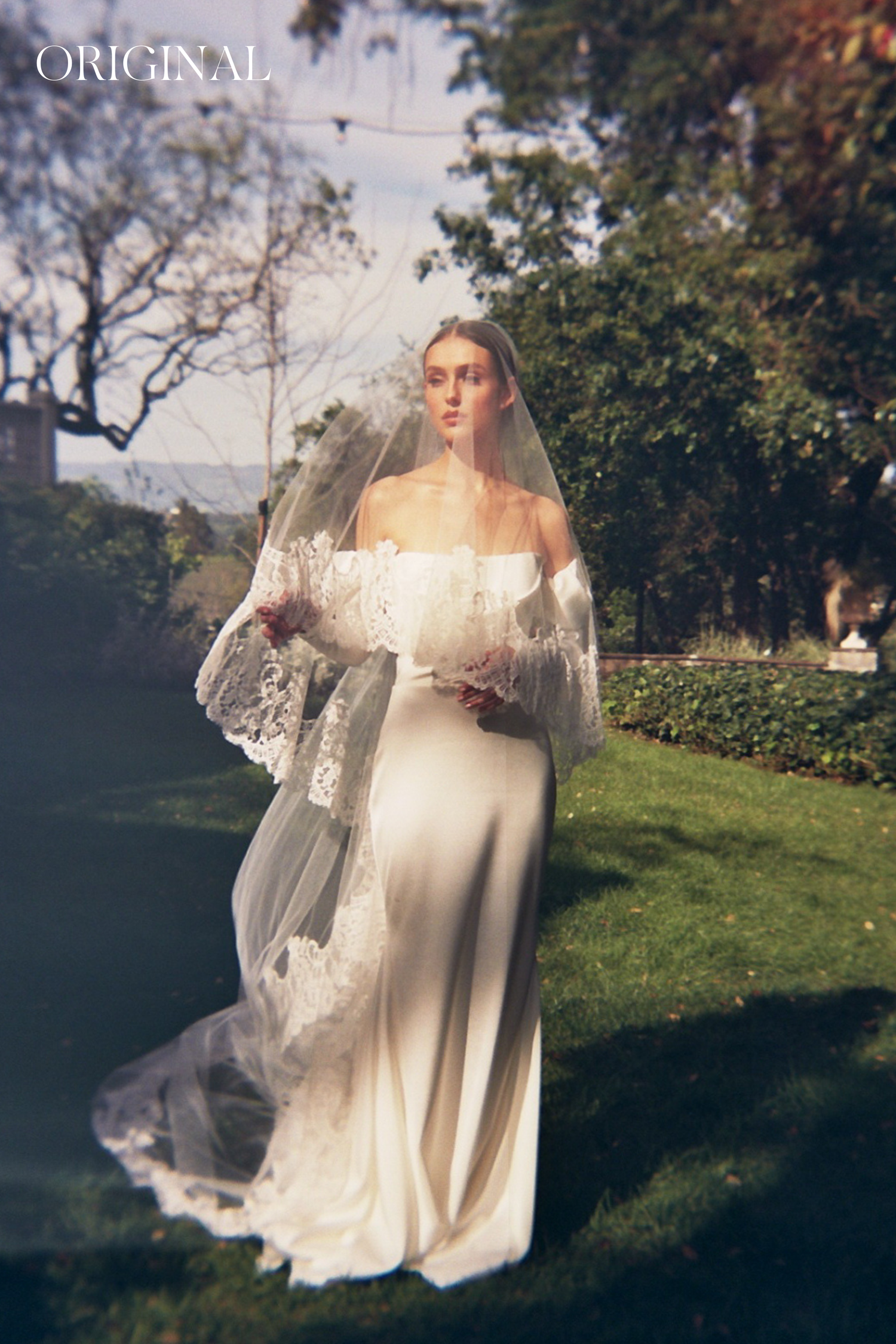 Dreamy outdoor maternity photos showing flowing cream dress and lace veil against natural backdrop.