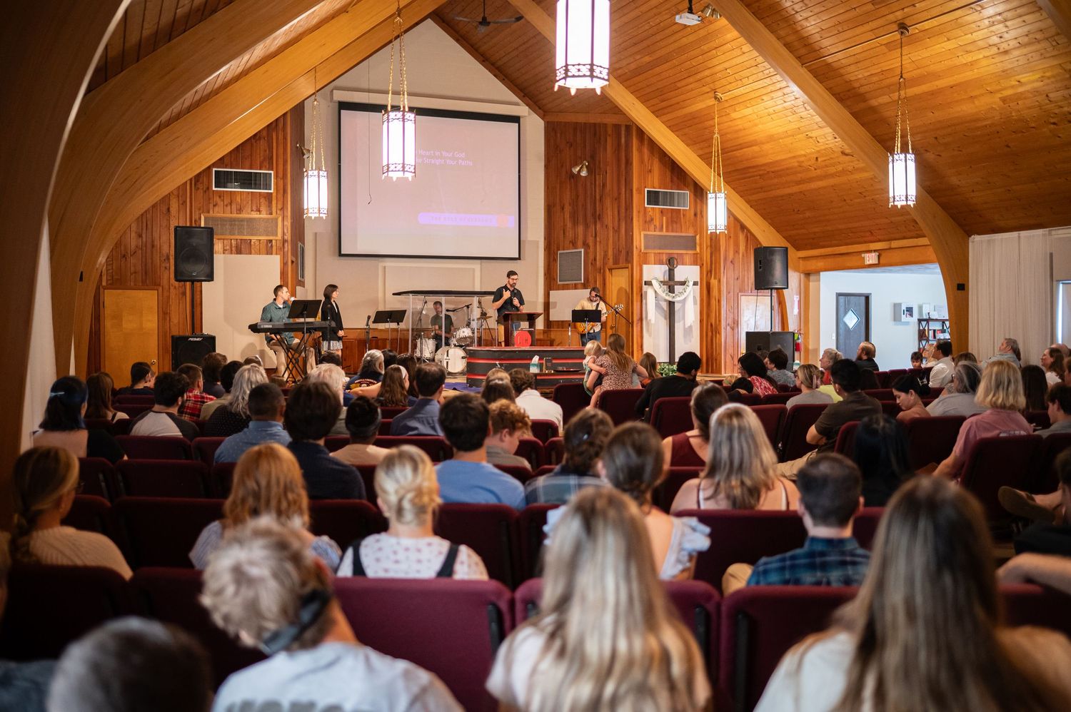 view from the back of the Crossroads Morgantown auditorium, filled with worshipers standing throughout the room during Sunday church service