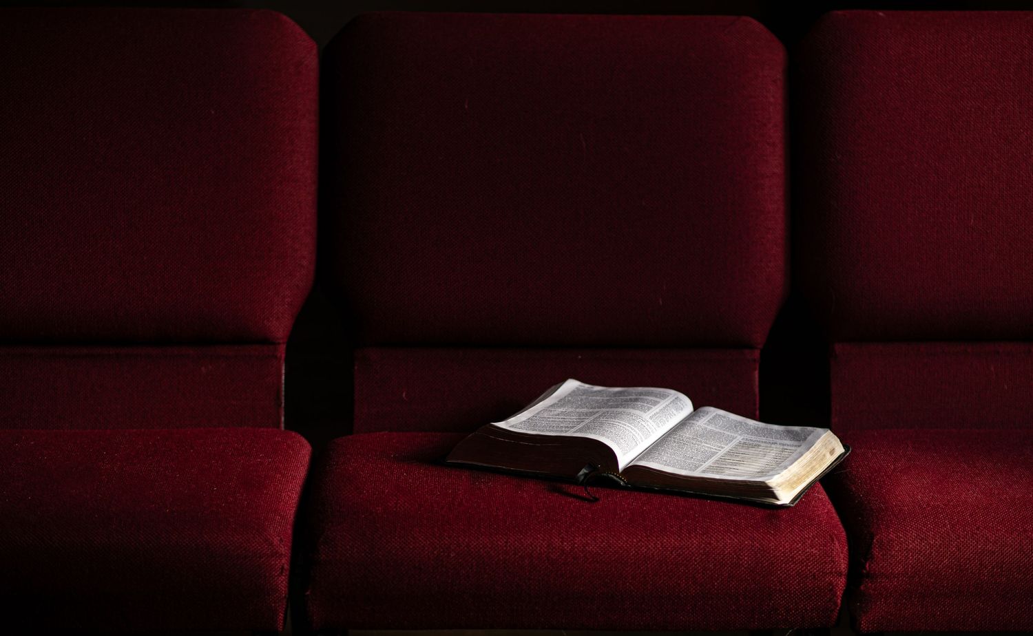 a large leather-bound Bible lies open on a row of dark red upholstered seats in the auditorium of Crossroads Church in Morgantown, WV