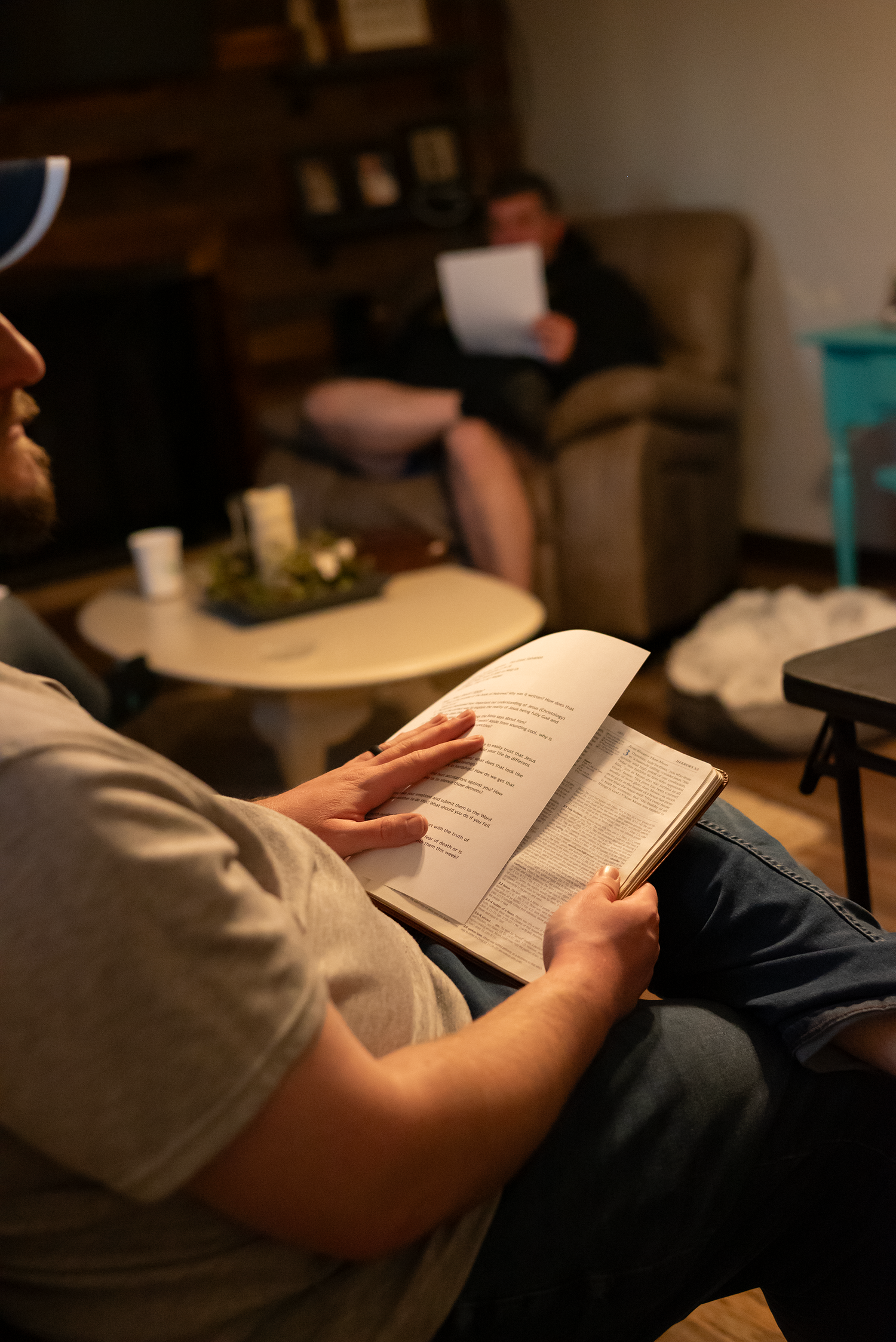 closeup of a man's hands holding an open Bible at a community group get together in a home in Fairmont, WV