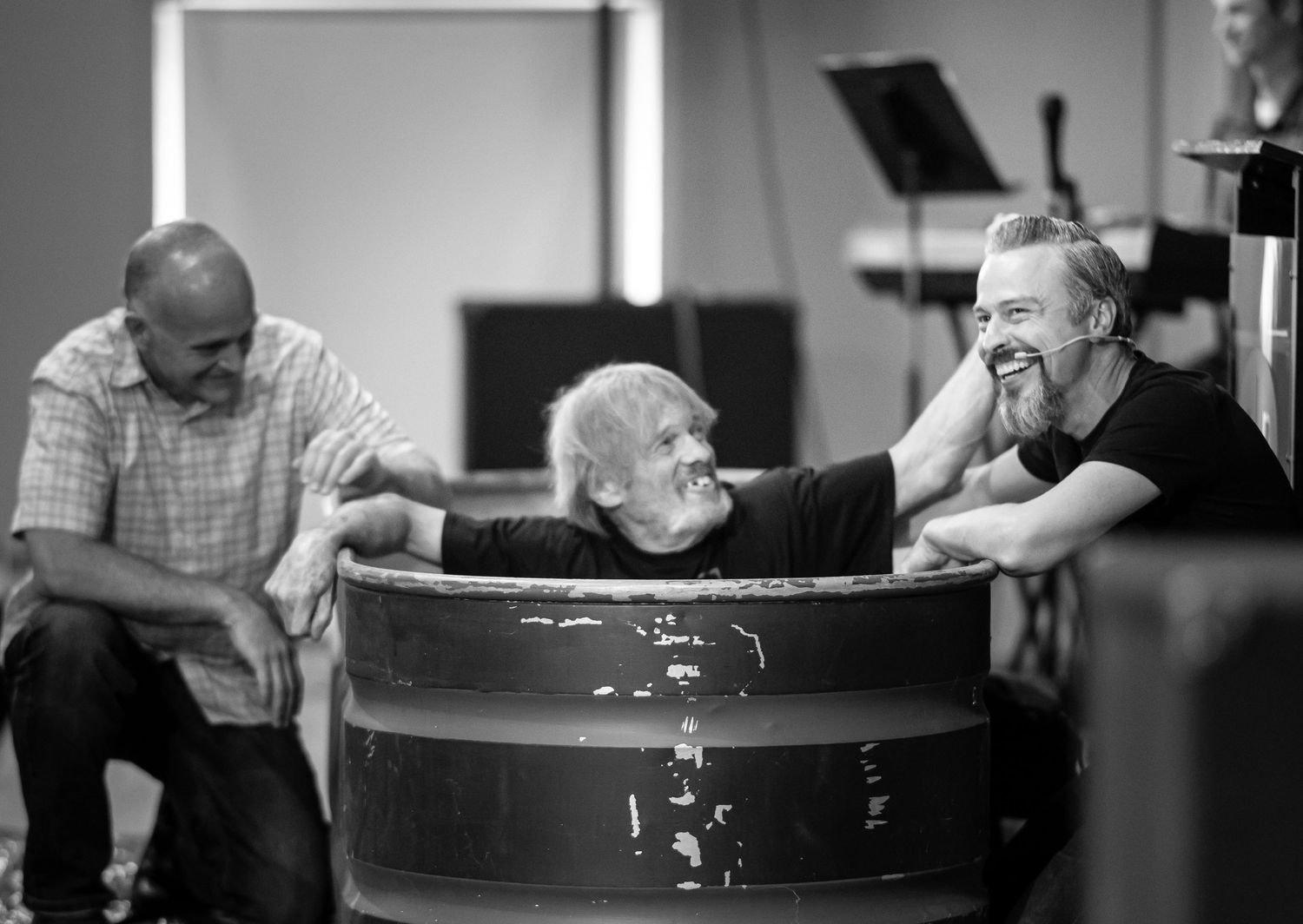 black and white image of an older man being baptized by on the Crossroads Morgantown stage by Pastor Chris and another church member
