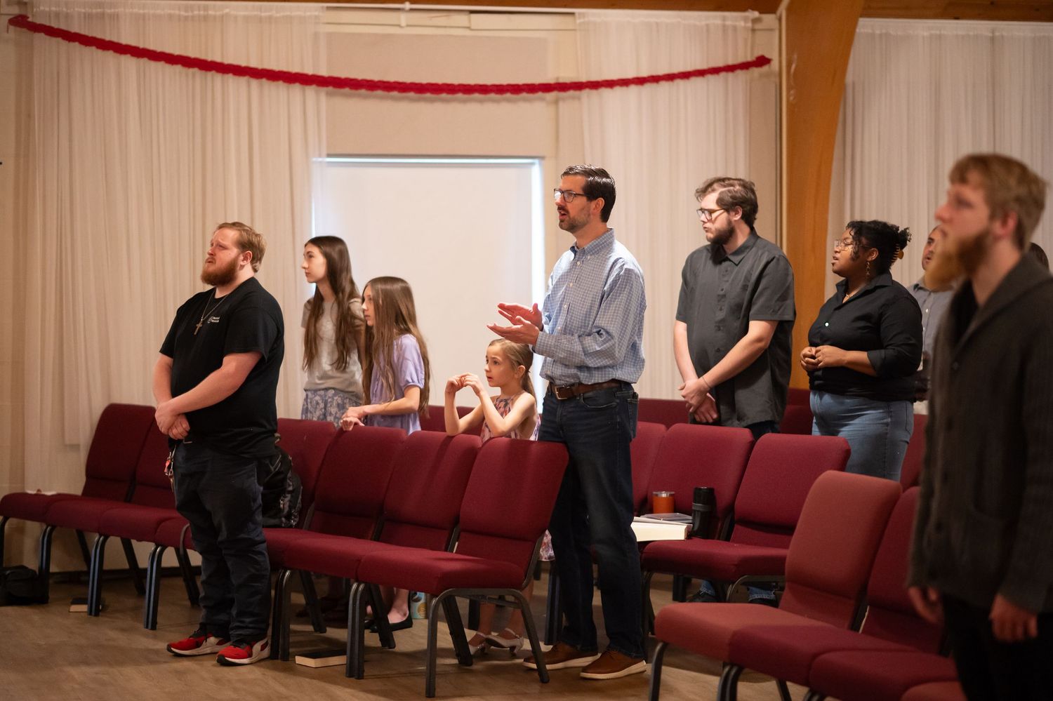 church members stand in the pews and sing during a Sunday morning church service at Crossroads in downtown Morgantown, WV