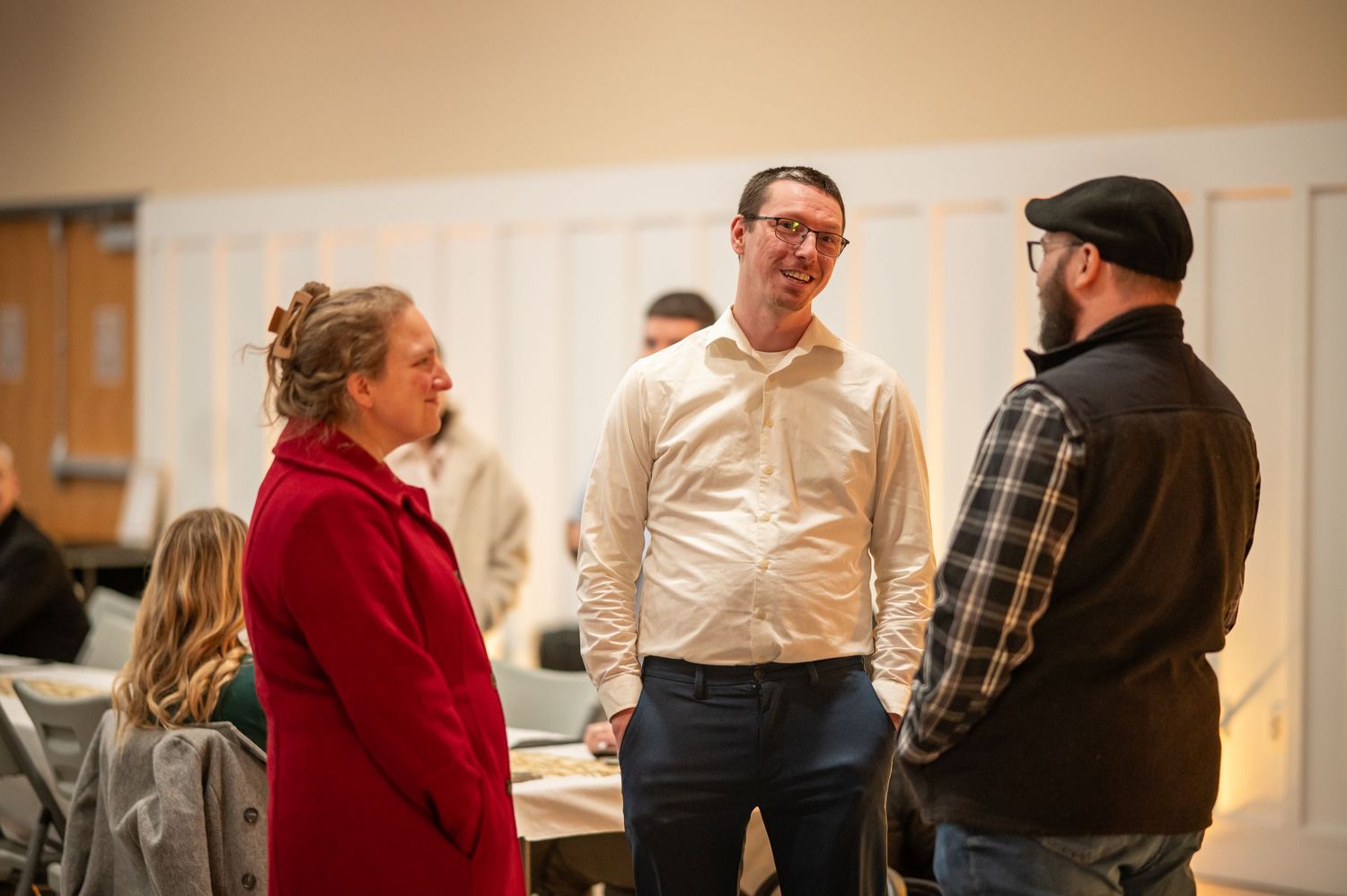 three members of Crossroads stand together talking and laughing at a Crossroads event