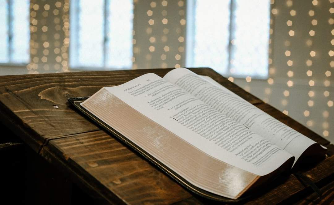 closeup of a leather bound Bible lying open on a rustic wood pulpit in the auditorium of Crossroads Fairmont