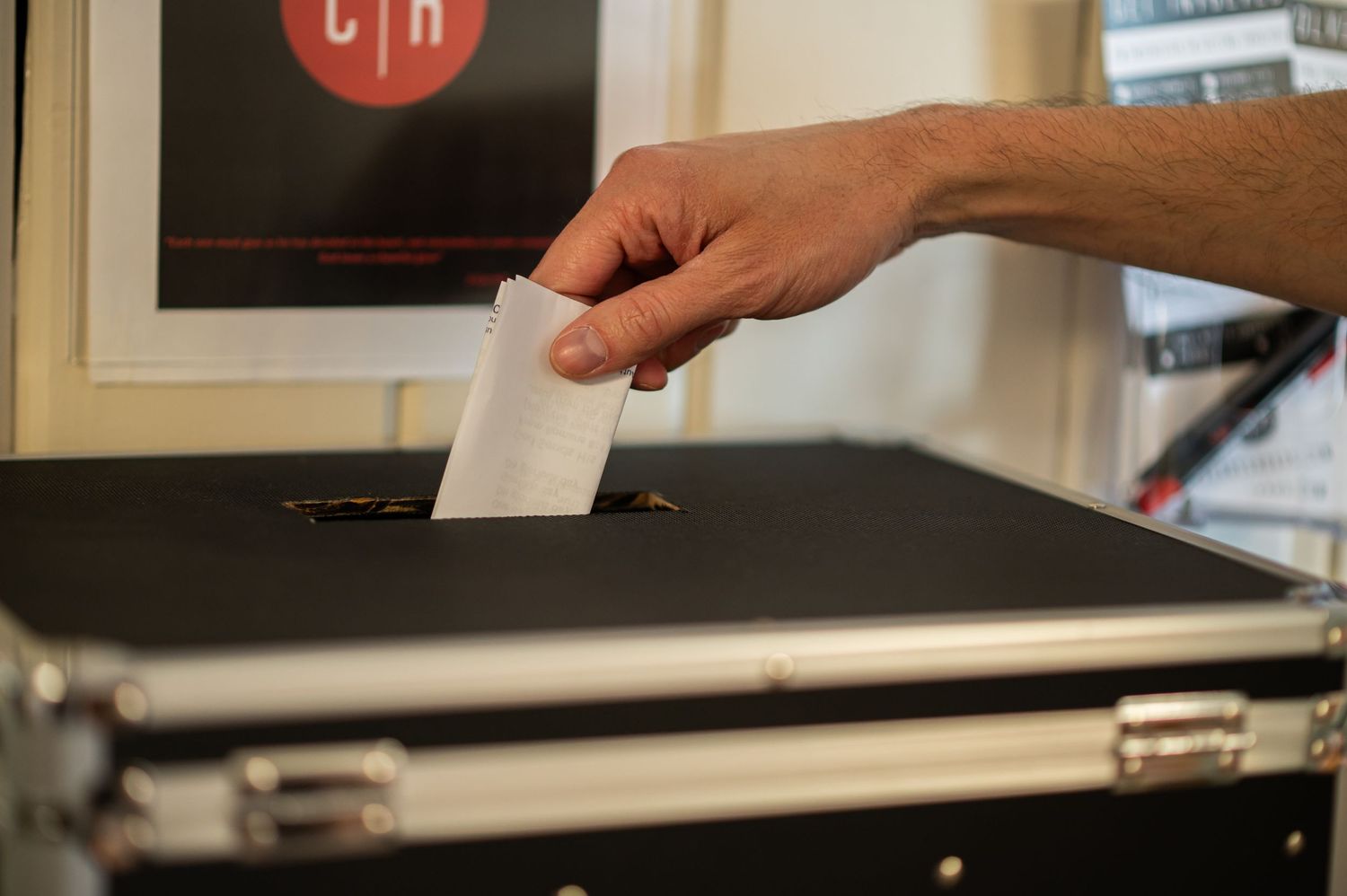 closeup of a man's hand dropping a folded check into a large black lockbox at Crossroads Church