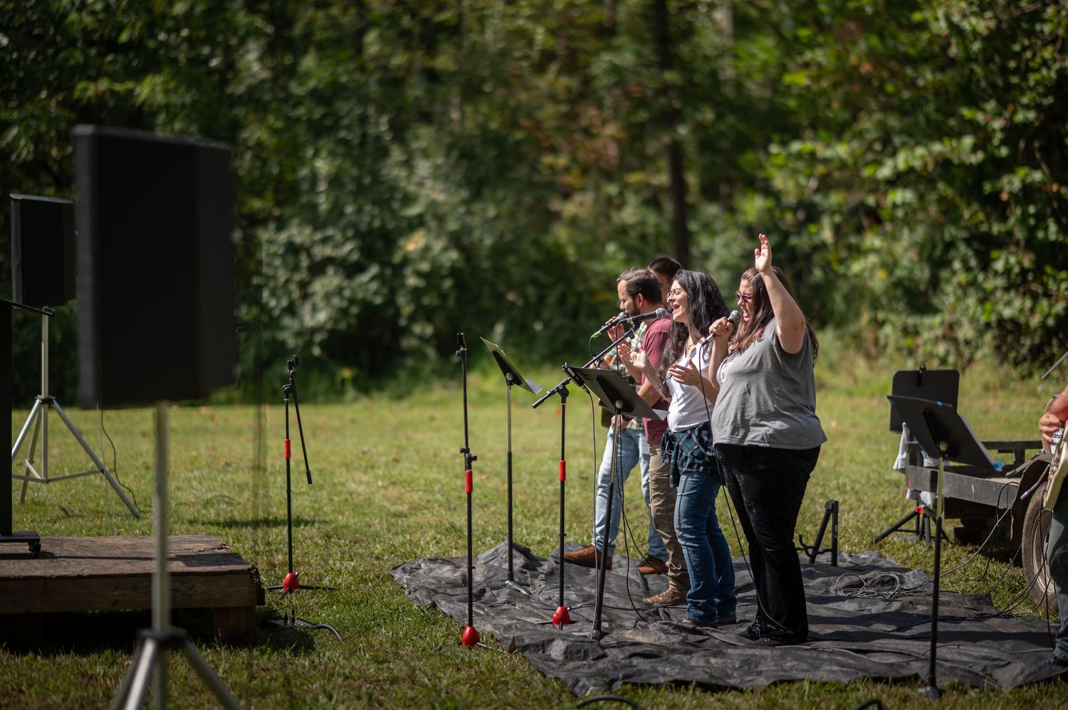 church members with instruments and microphones lead singing during an outdoor church service on a Sunday morning in Morgantown, WV