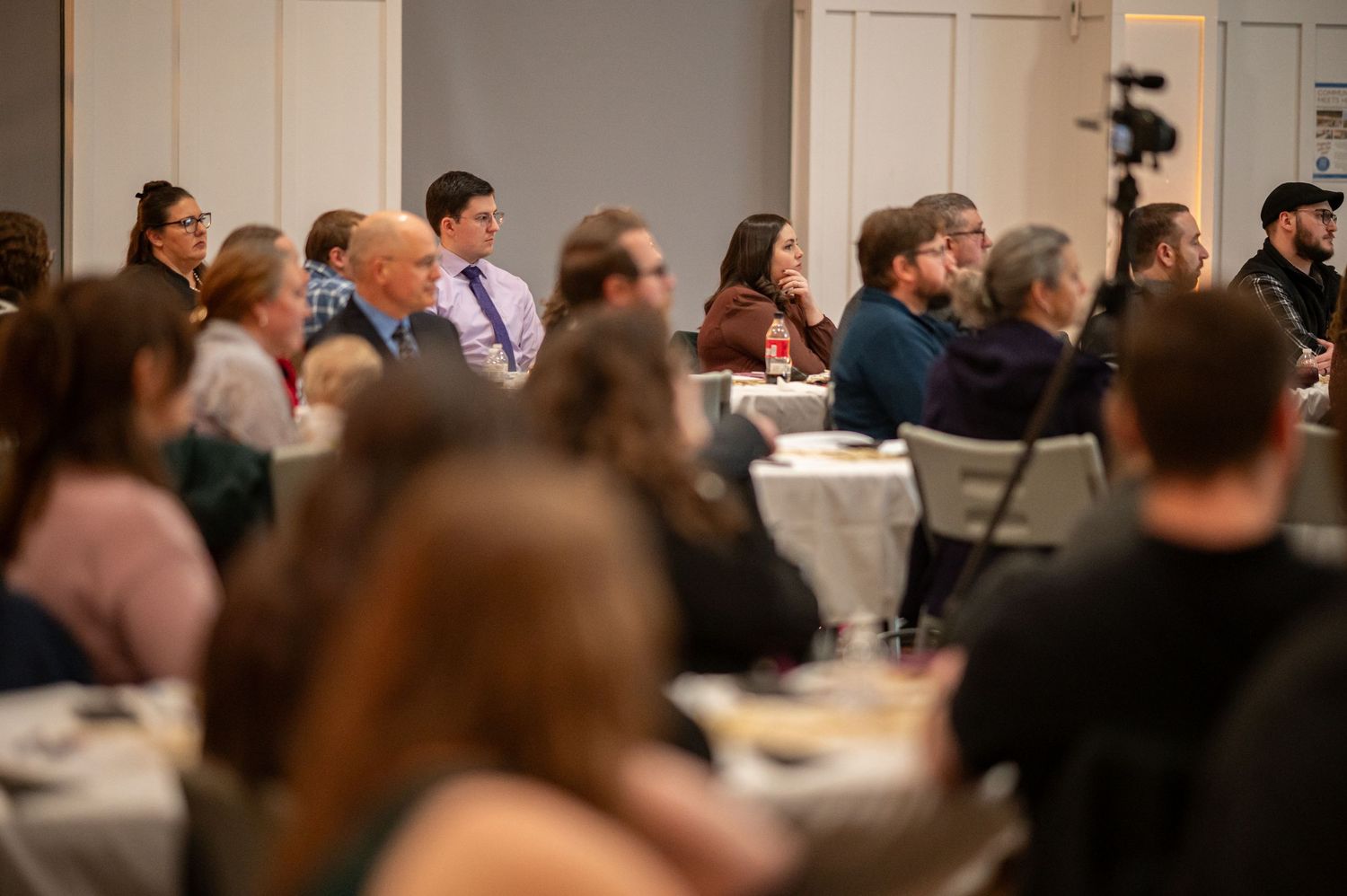 A crowded conference room filled with attendees seated at tables during a Crossroads church event.