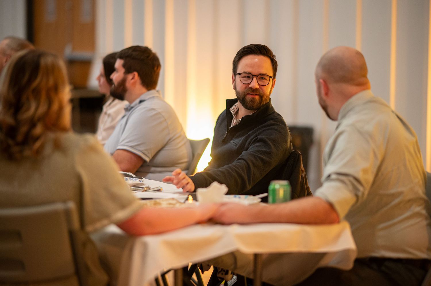 Crossroads members seated at a table chat during a Crossroads event