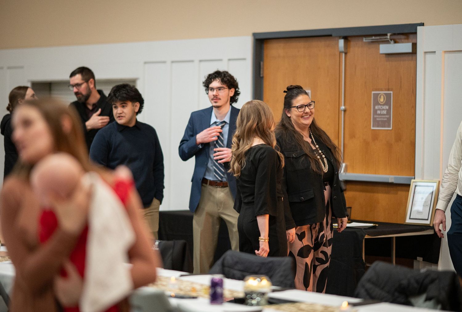 a group of Crossroads members talk and laugh together at an event