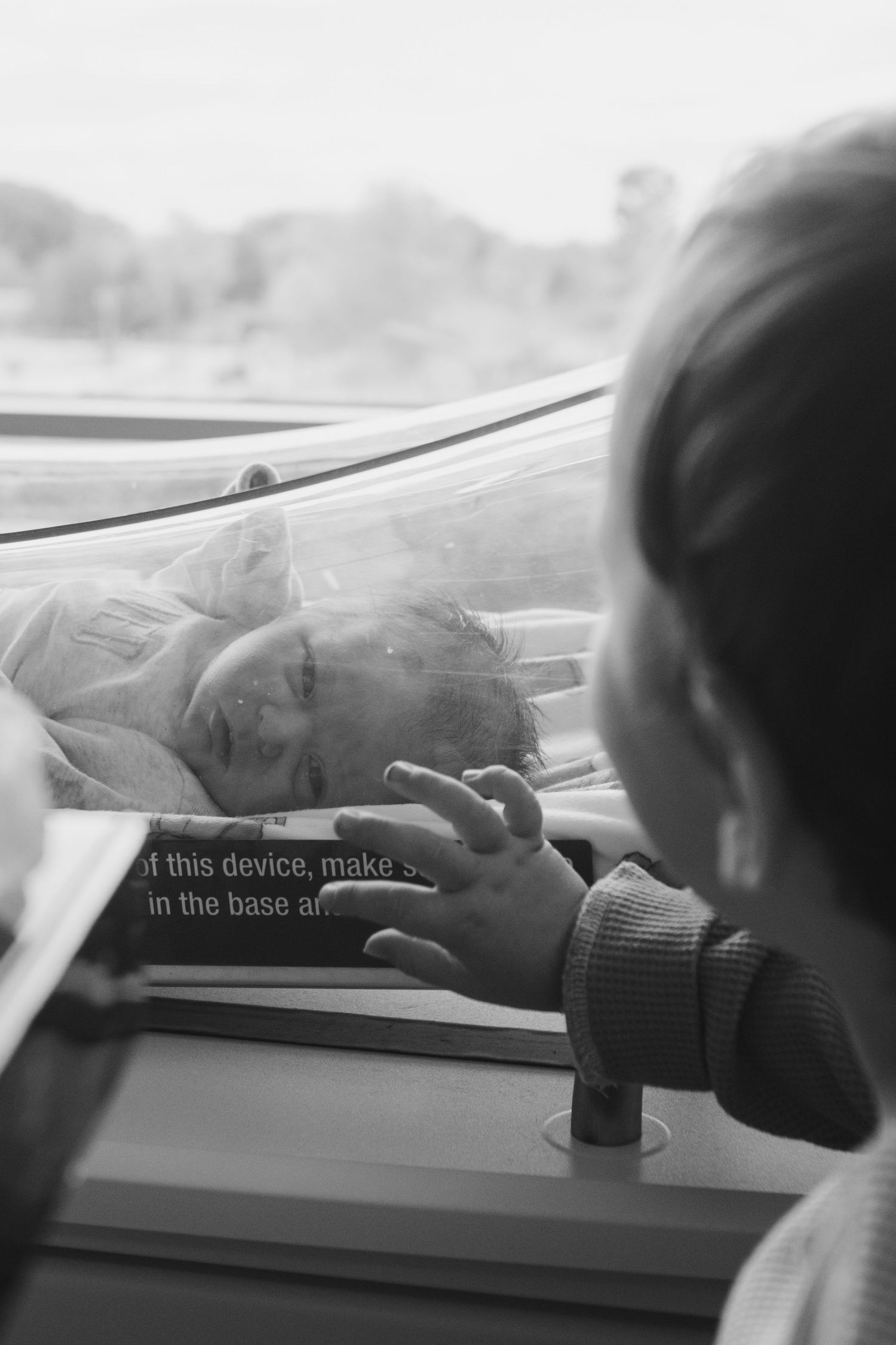 A series of black and white photos showing someone using a device through a car window.