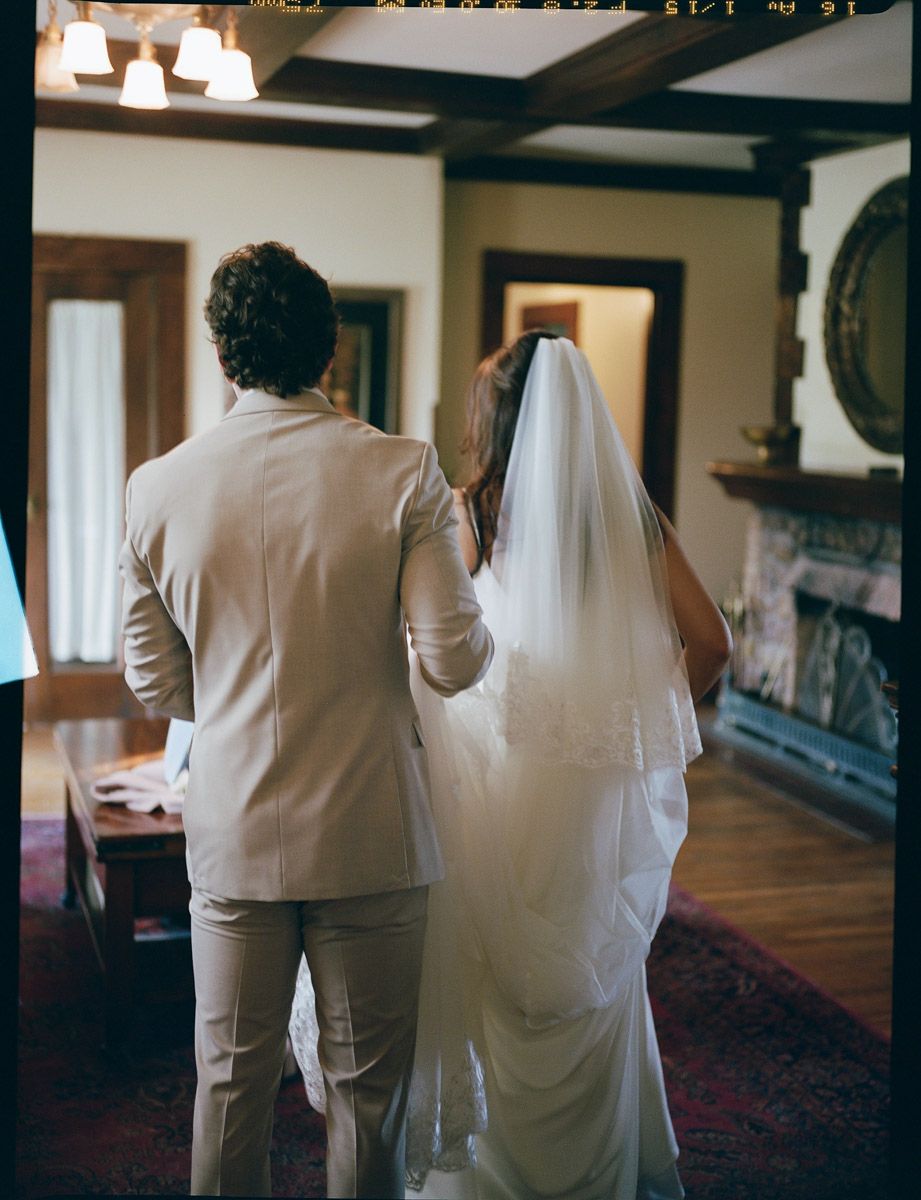 Bride and groom walking through a classic old Arizona wood-paneled room.