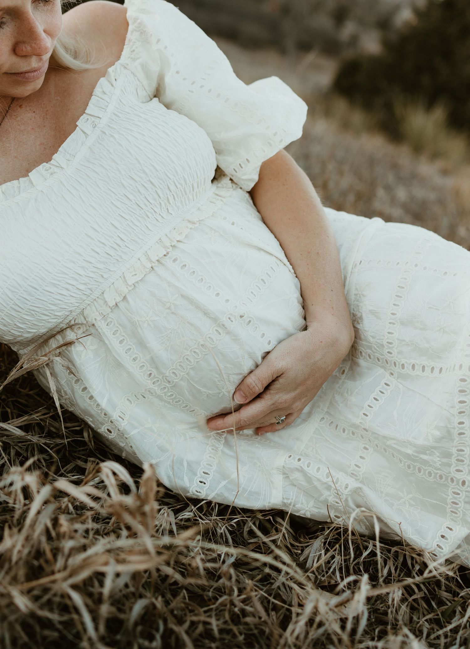 Dreamy portrait of an ethereal white lace dress with puff sleeves in a rustic outdoor setting.