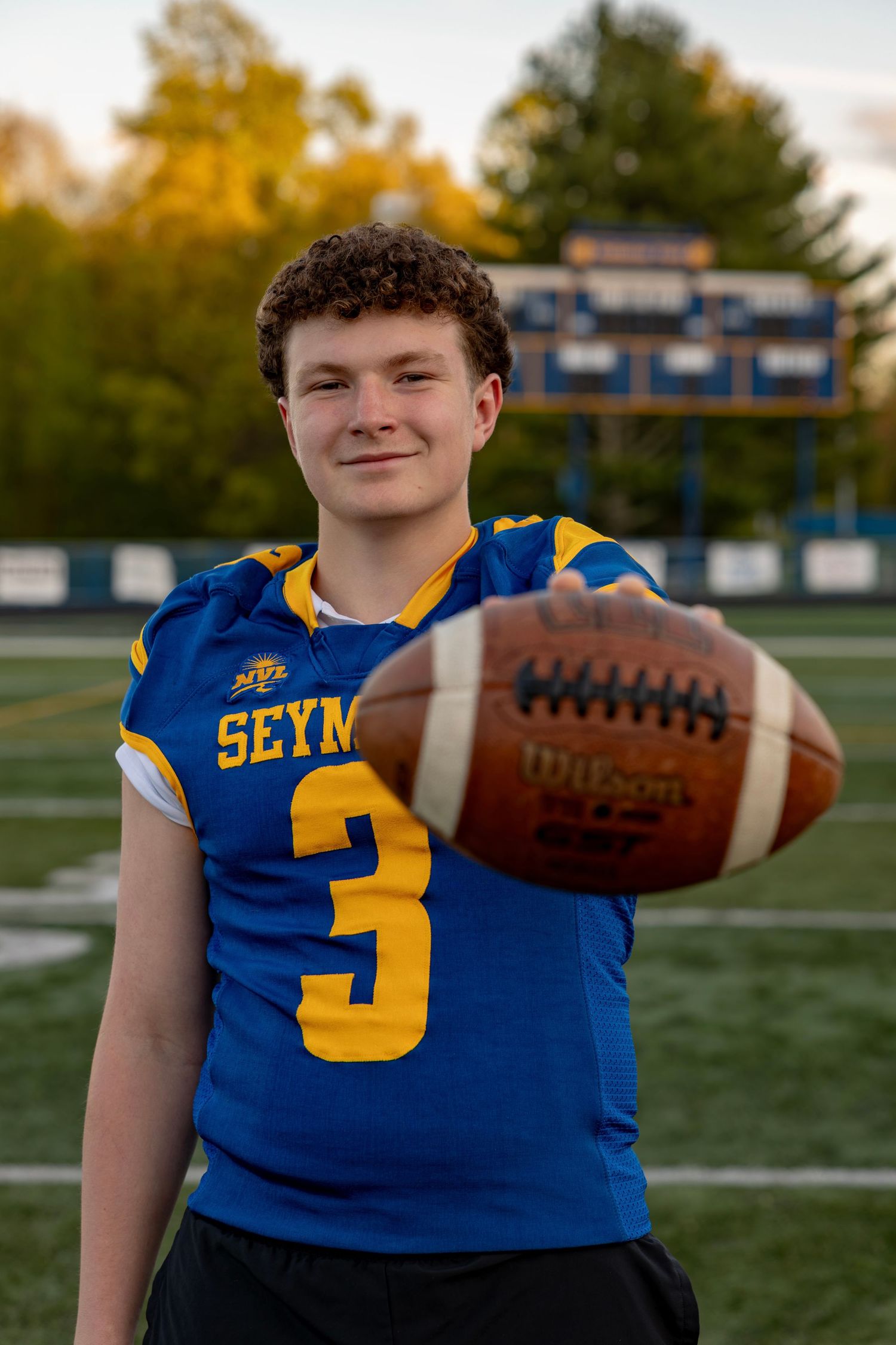 Seymour High School football player number 3 holding Wilson football toward camera.