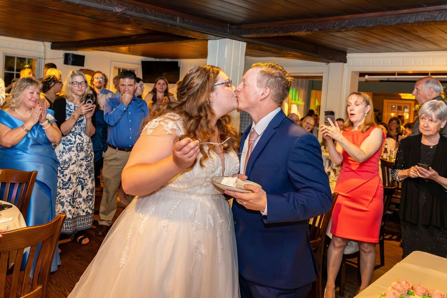 Bride and groom share a kiss after cake smashing at their wedding reception.