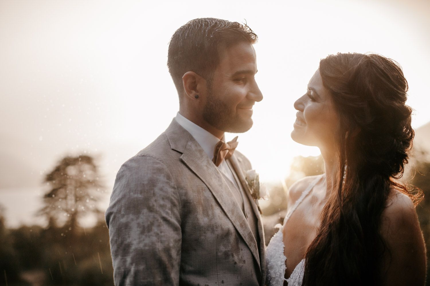 Romantic wedding couple gazing at each other during golden hour sunset with soft warm light.