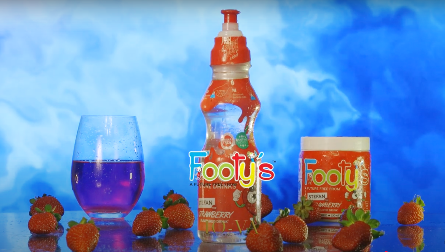 Footy's strawberry flavored drink bottle and gummies displayed with fresh strawberries.