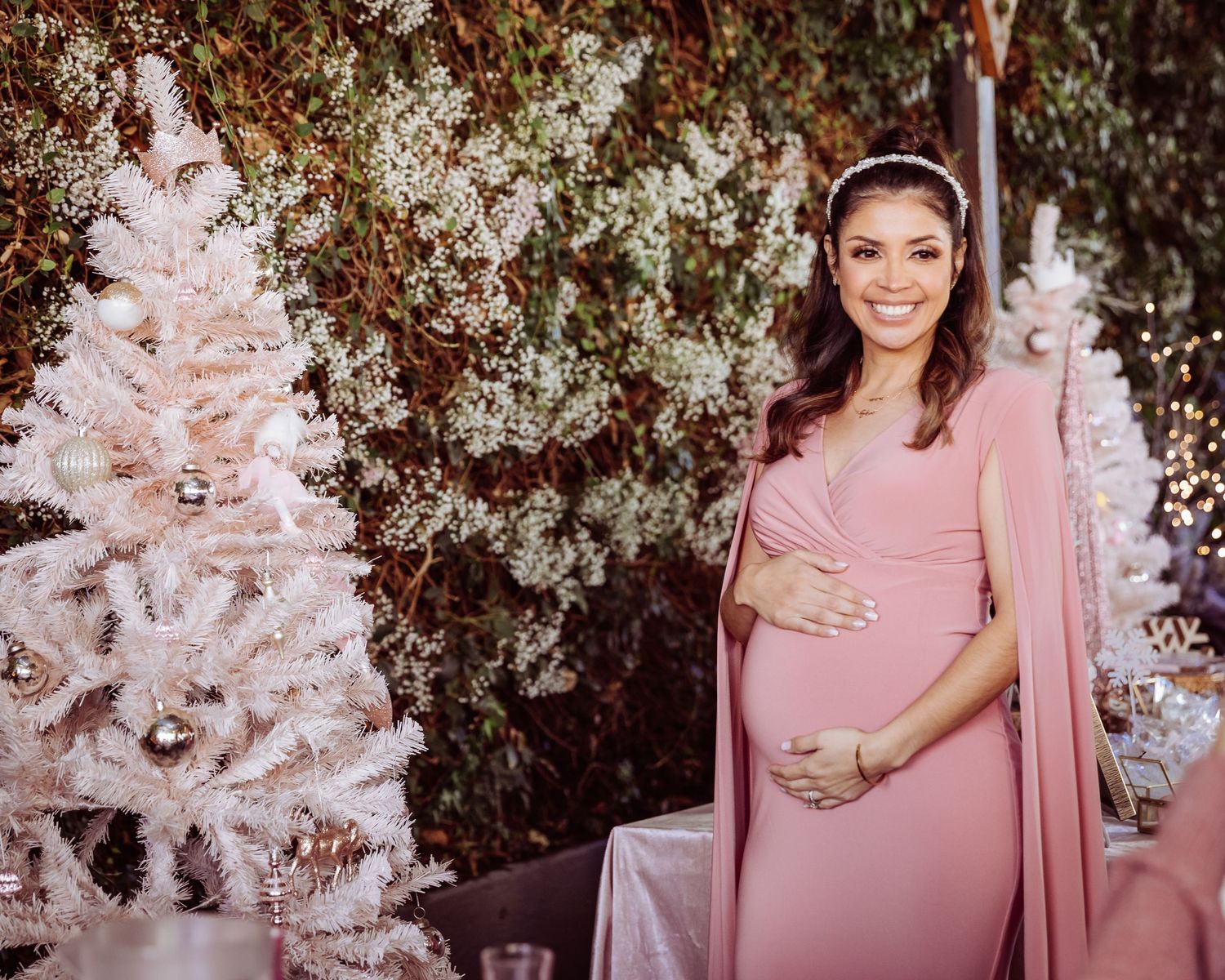 A maternity celebration scene with pink Christmas trees and elegant holiday decor.