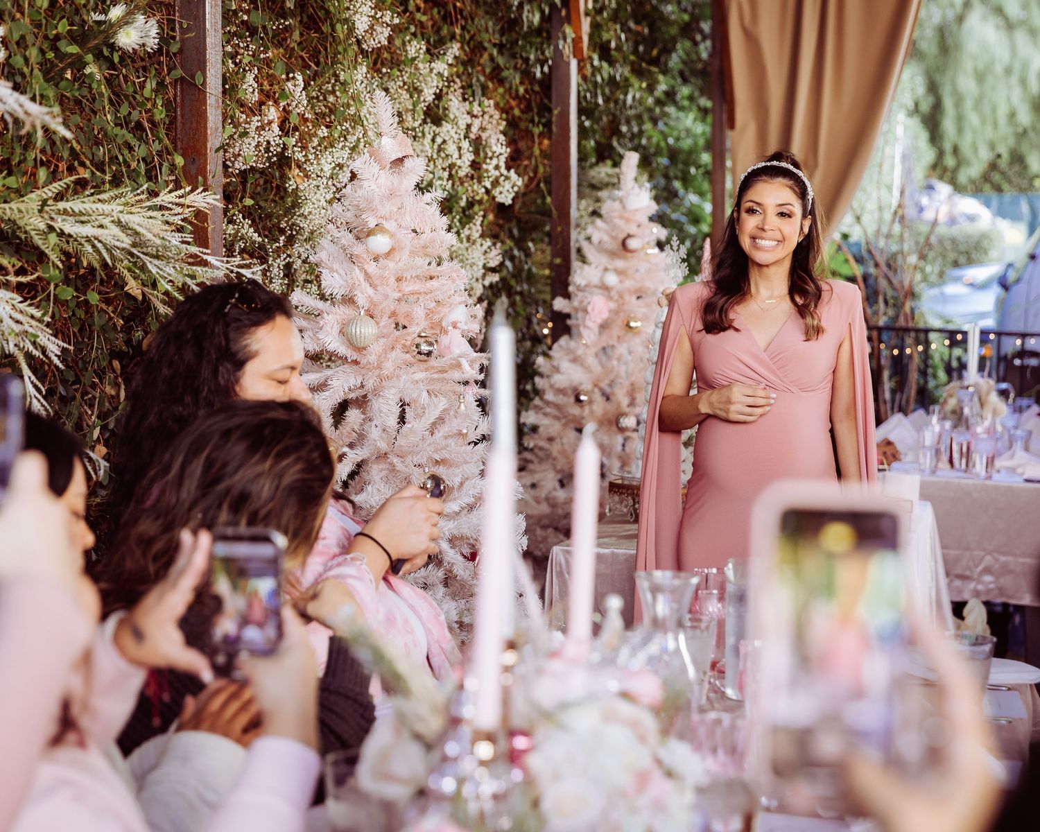 A celebration setup with pink Christmas trees and elegant table decorations at a festive event.