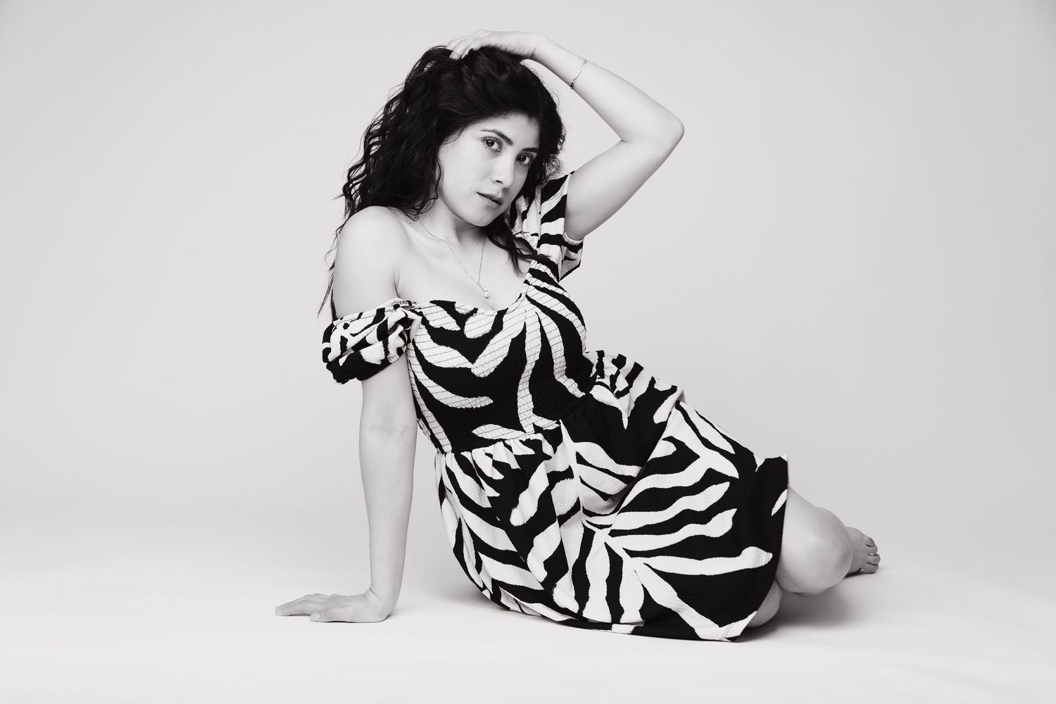 Artistic black and white portrait of a model in zebra print dress.