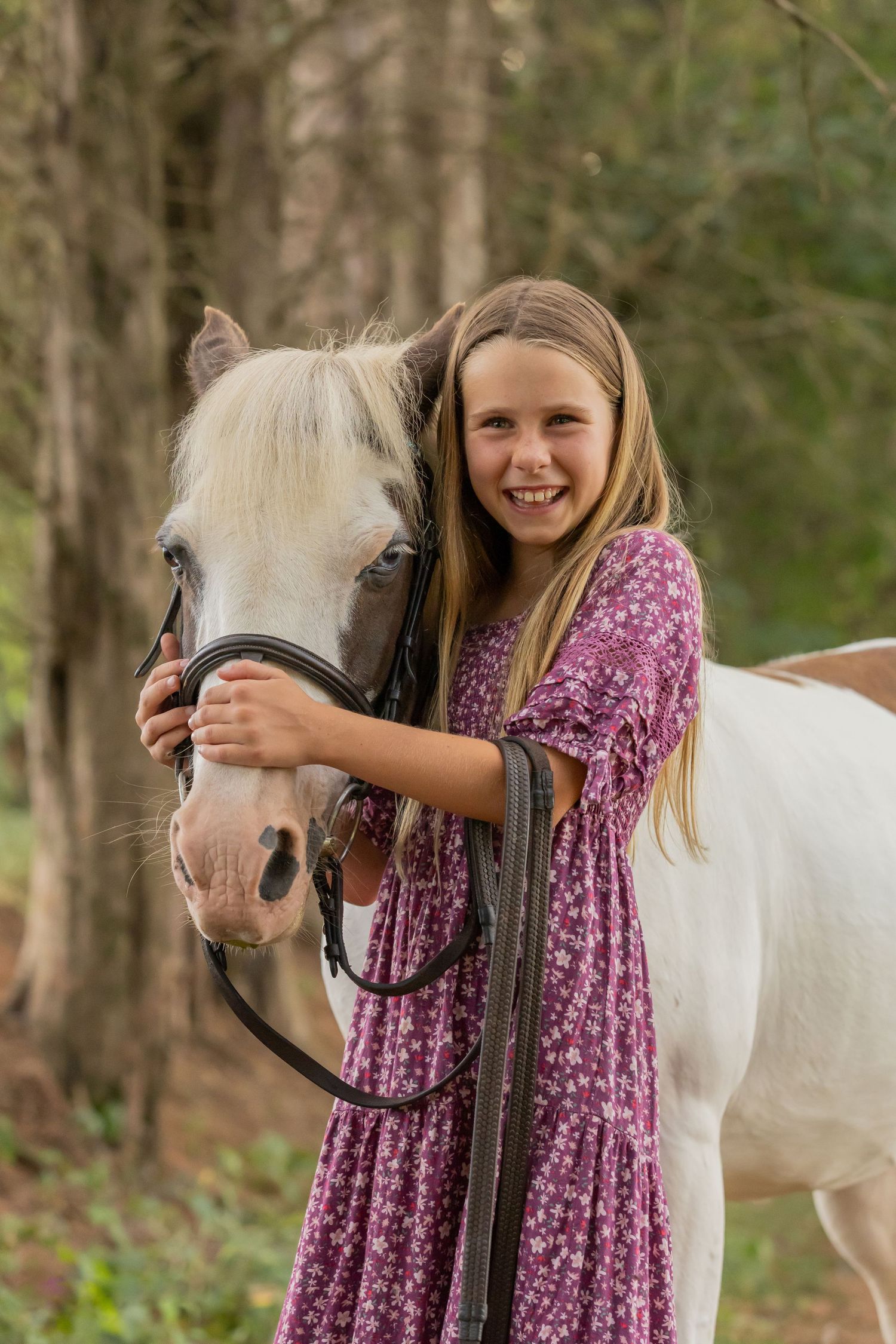 White pony and companion posing together in forest setting.