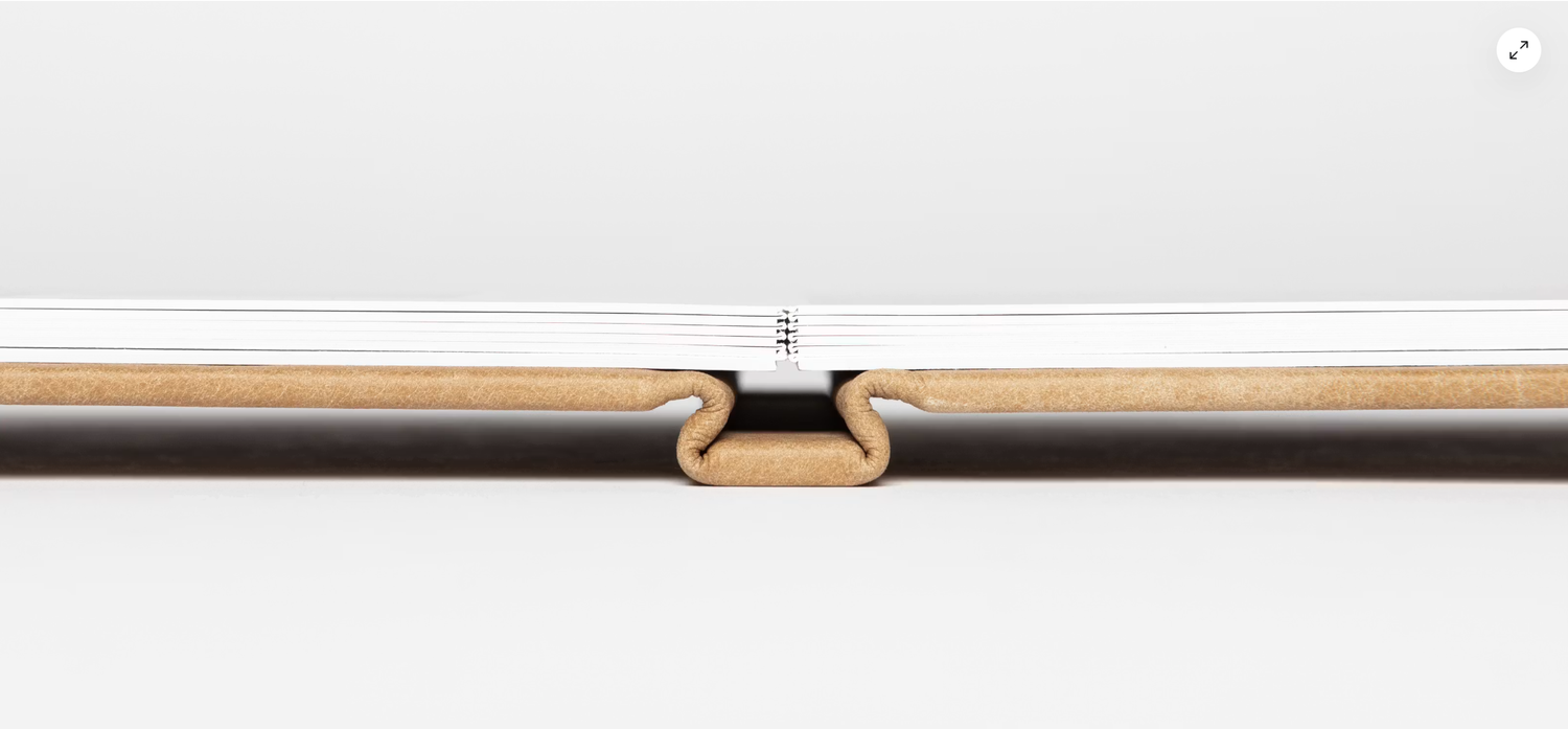 Close-up of a wooden blind headrail with a white center connector clip showing precise assembly detail.