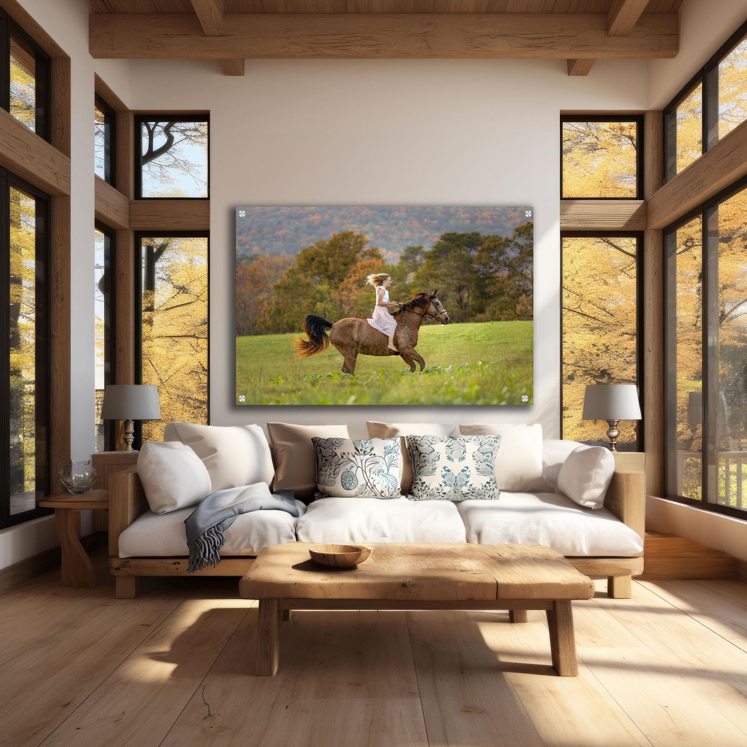 A rider on a brown horse galloping across a lush green field with autumn trees in a bright living room.