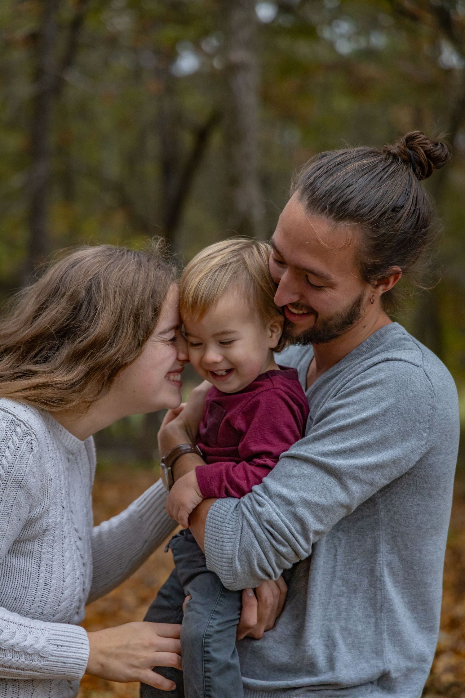 A tender family moment sharing cuddles and laughter together outdoors during autumn.