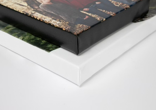 Two canvas prints stacked, showing gallery-wrapped edges with a black and white frame finish on a white surface.