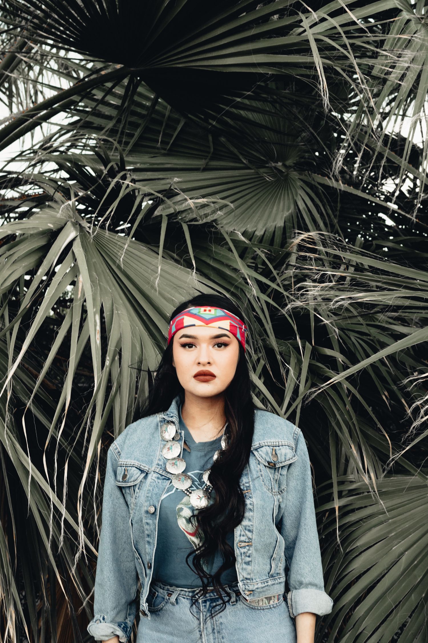senior girl in denim jacket under palm tree, Palm Springs senior photographer