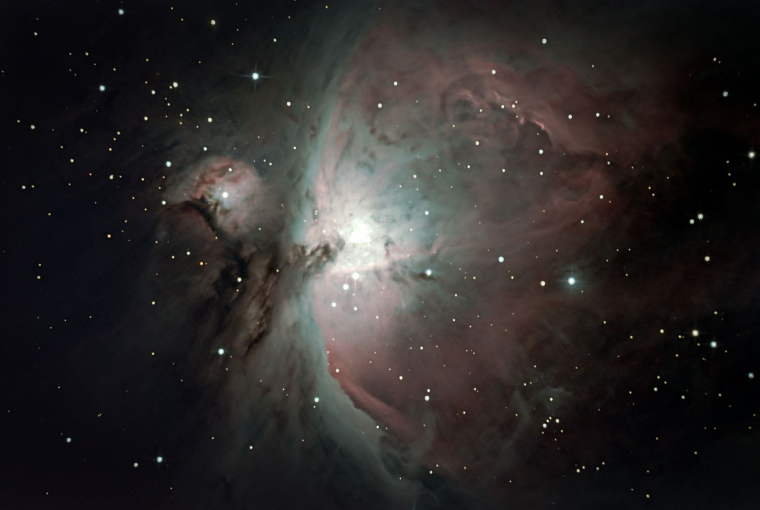 Stunning Orion Nebula deep space photograph showing glowing pink and white gas clouds surrounded by stars.