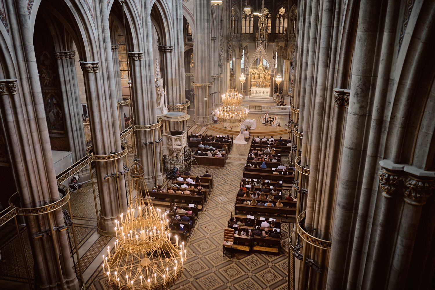 Elegant wedding in gothic Cathedral in Vienna. Chandeliers and columns. Catholic photogtapher Europe.