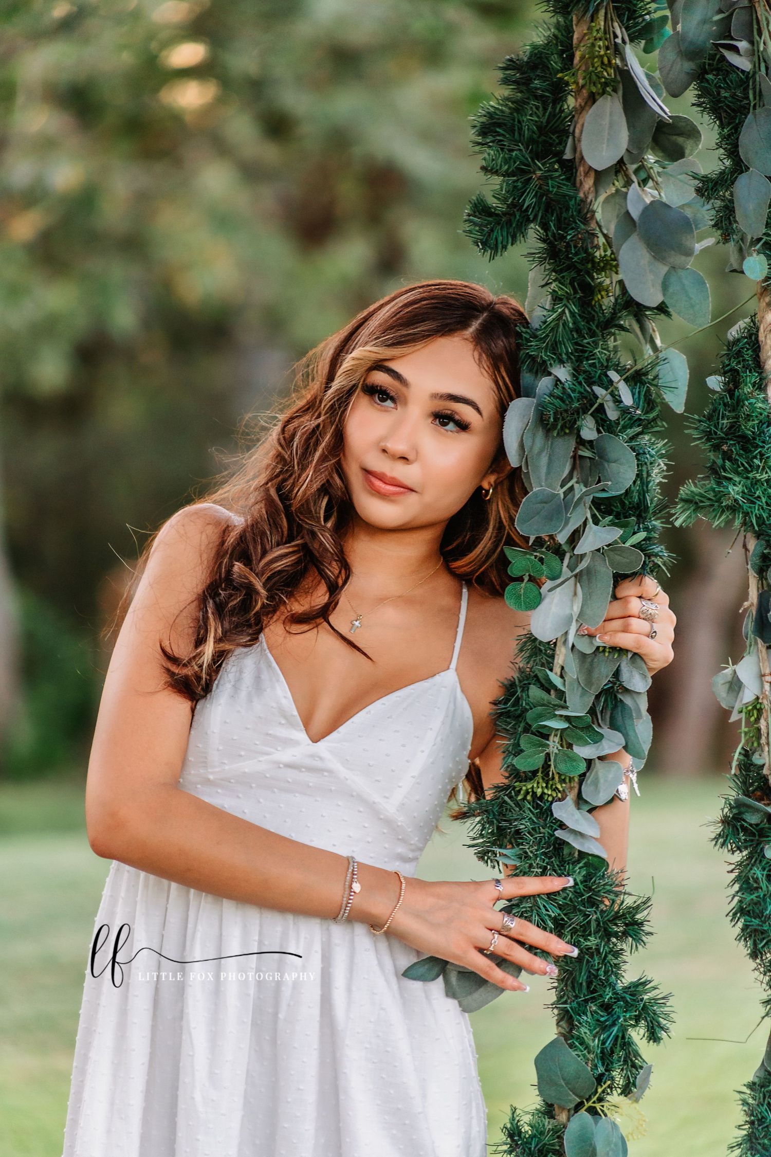 senior girl leaning on swing and looking away