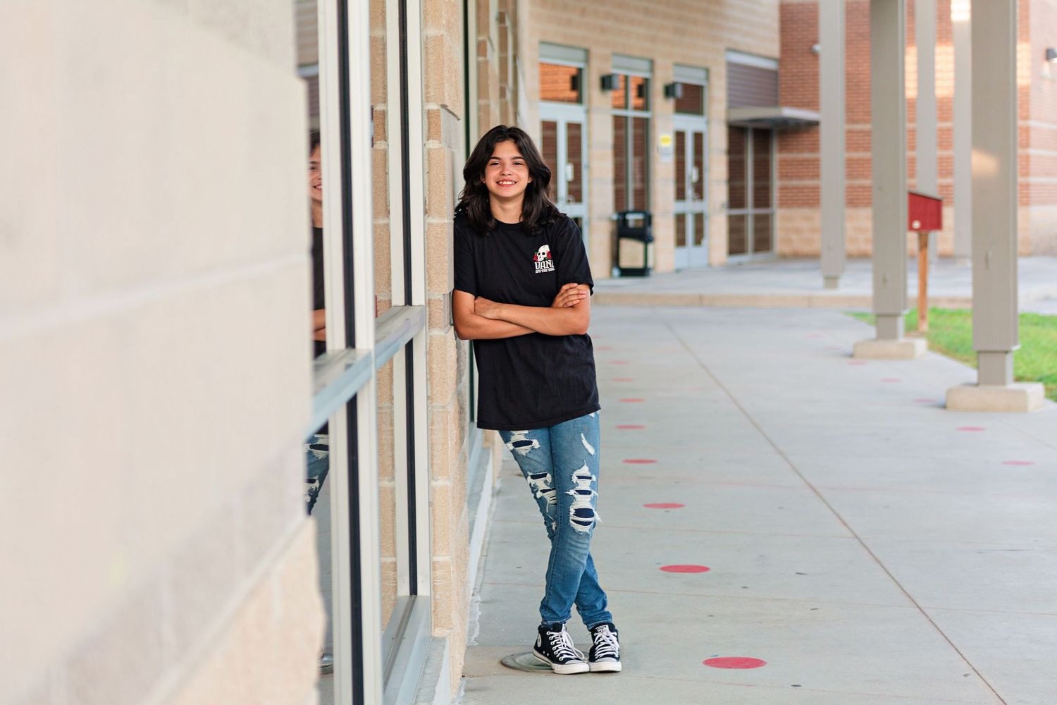 Young girl standing in front of school building for portrait photo