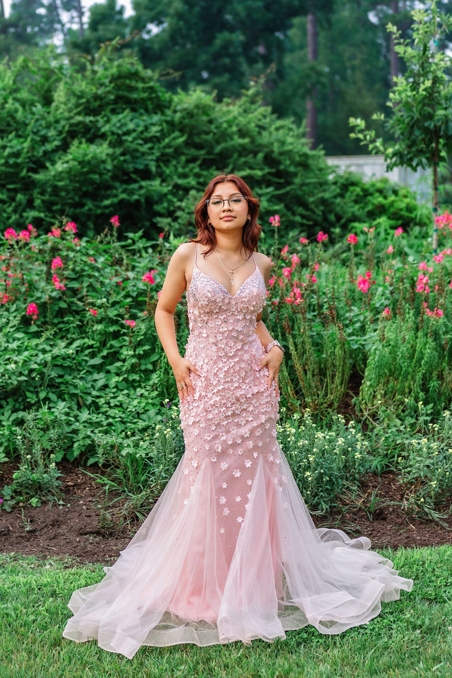 Portrait of senior girl in elegant pink prom dress with park background