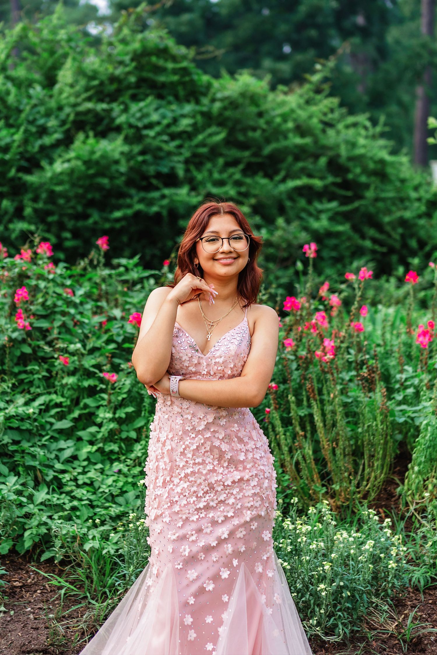 Senior portrait of girl in pink dress smiling in park