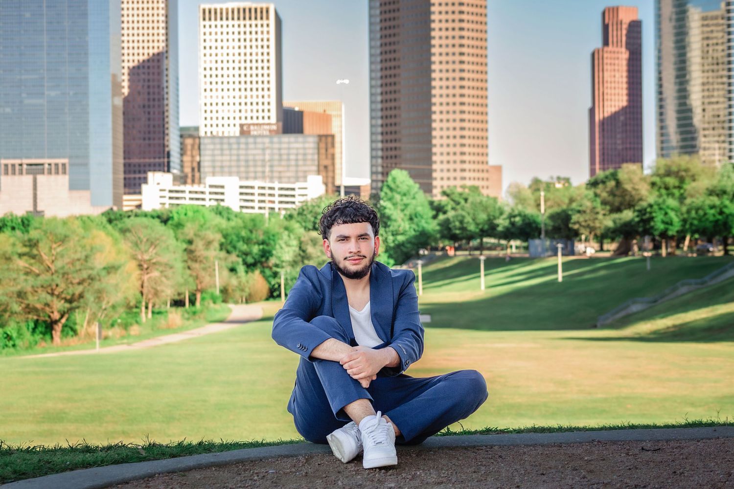 Senior boy posing with downtown skyline in the background