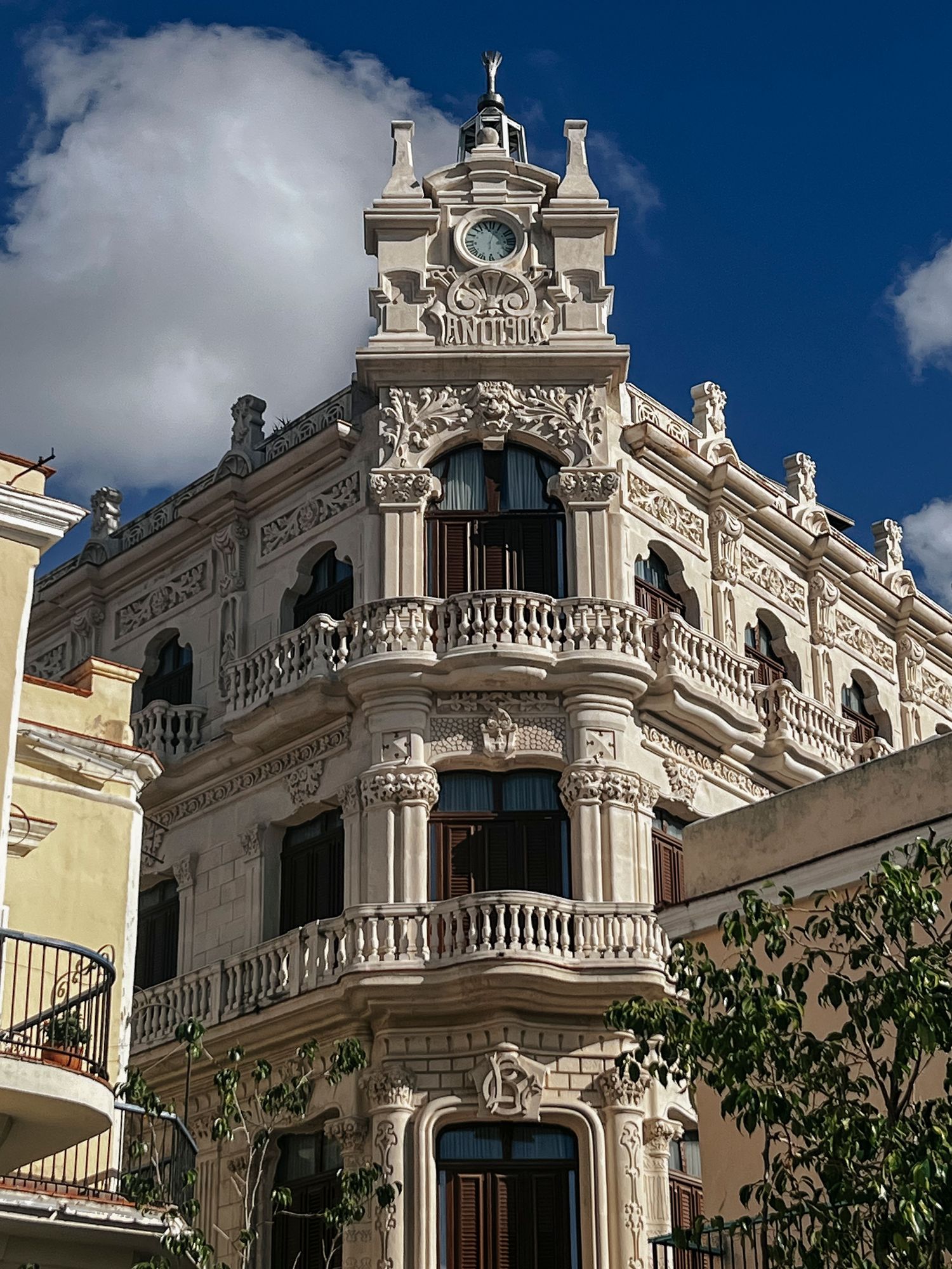 Ornate historic building facade with elaborate balconies and architectural details against blue sky.