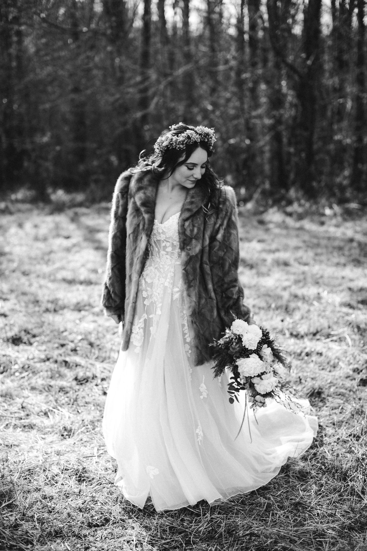 A classic black and white bridal portrait of a bride in a fur coat and flower crown at The Barn At Young Harris wedding venue in North GA