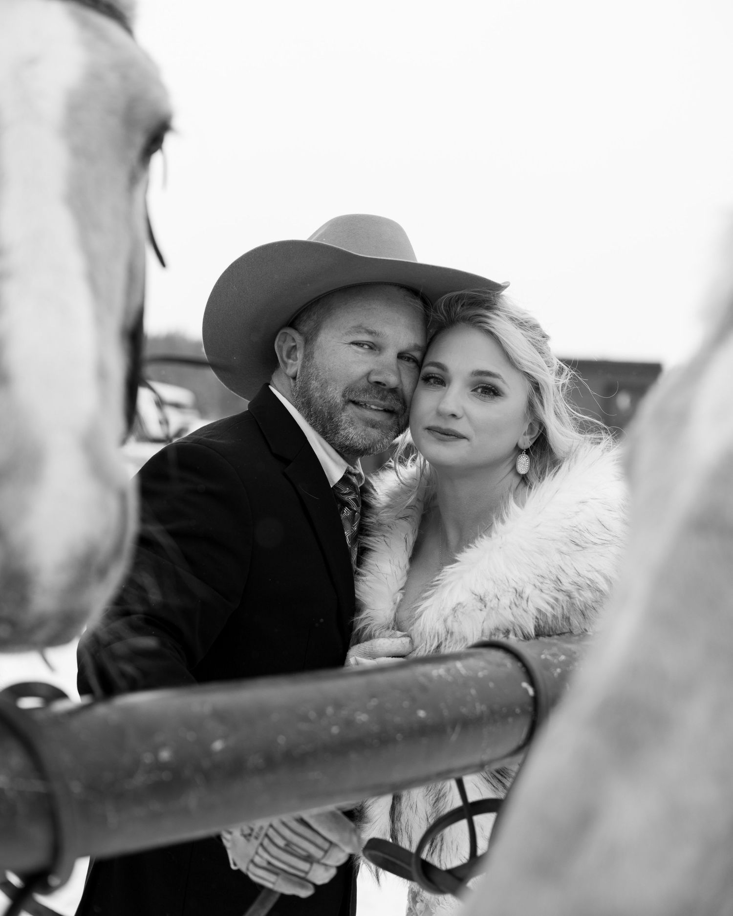 A romantic black and white portrait series showing a couple in western wear sharing tender moments.