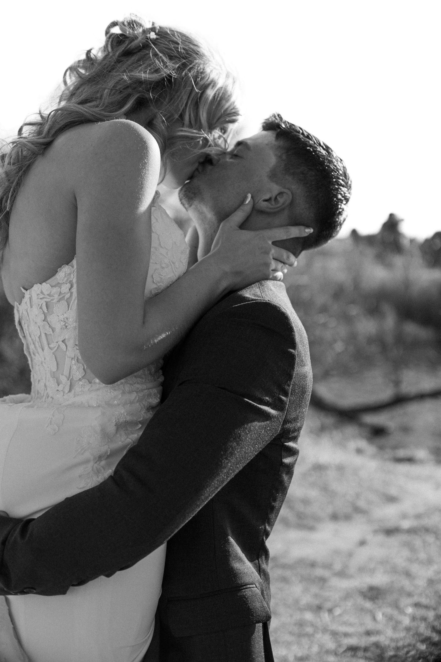 A romantic black and white photo series showing a couple embracing and kissing in an outdoor setting.