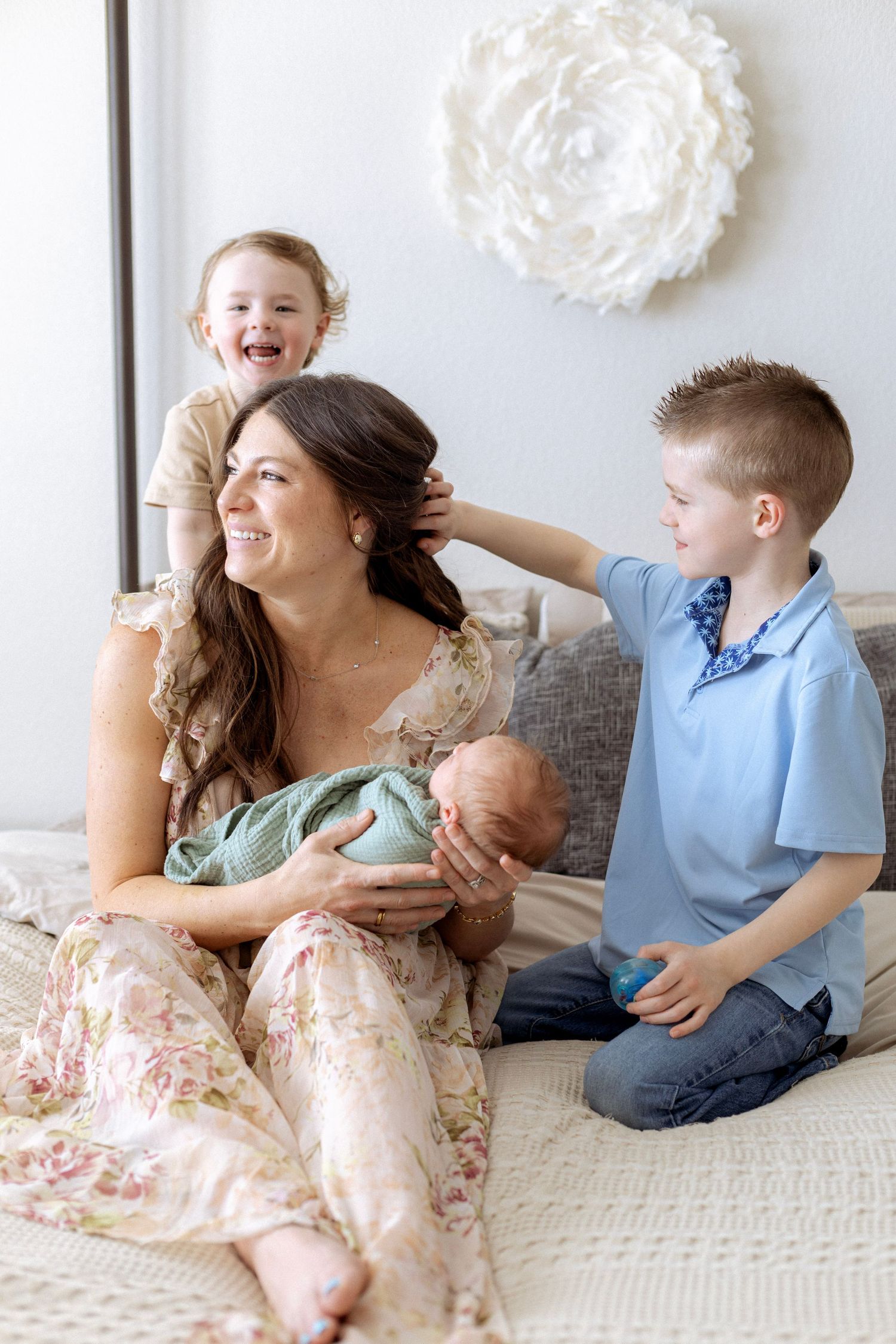 A heartwarming series of candid family moments showing playful interaction on a couch with white decorative pom poms on the wall.