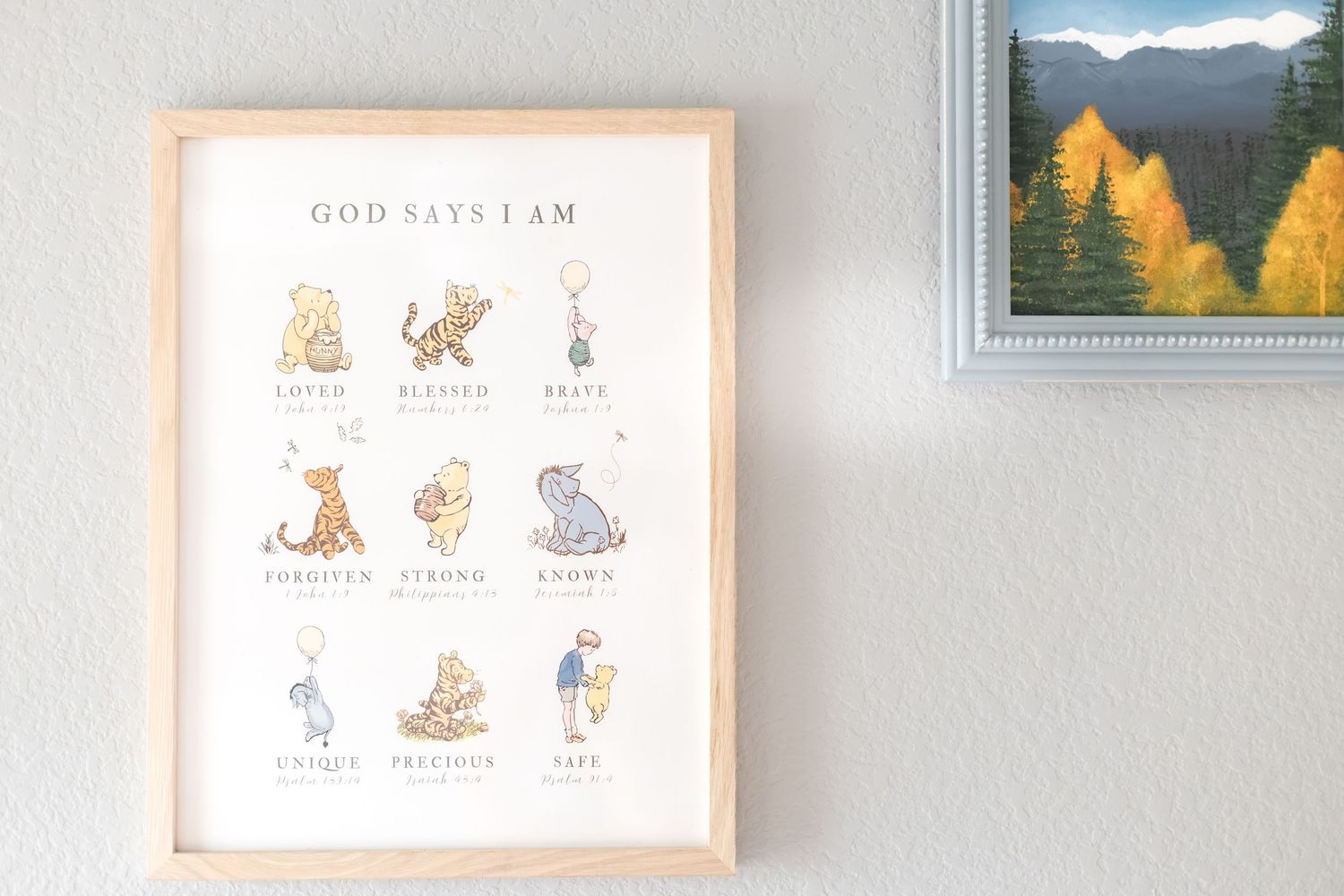 Framed Winnie the Pooh “God Says I Am” print with classic illustrations in a natural wood frame on a white wall.