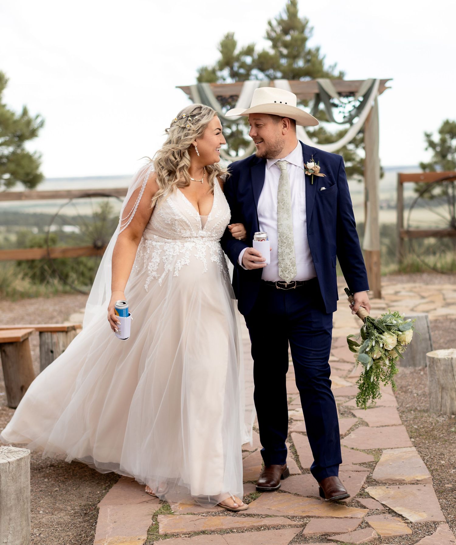 Bride and groom in cowboy hat sharing a loving glance while walking together after ceremony.