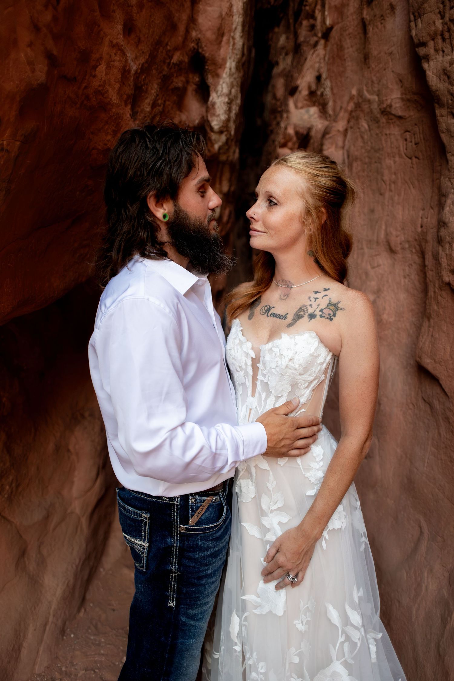 Bride and groom sharing an intimate gaze in a red rock canyon at Garden of the Gods wedding.