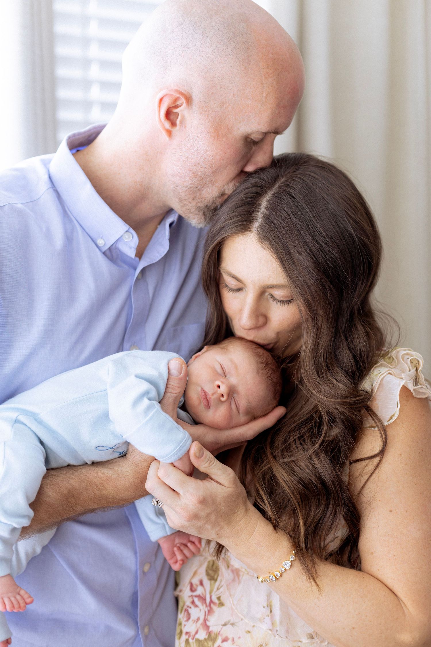 A romantic couple in light colored clothing share tender kisses in a series of intimate portrait photographs.