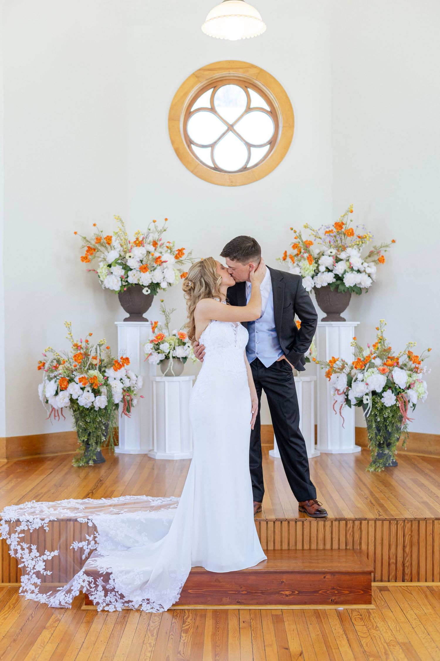 A romantic wedding photo sequence showing a couple dancing and dipping in front of a floral backdrop with white decor.