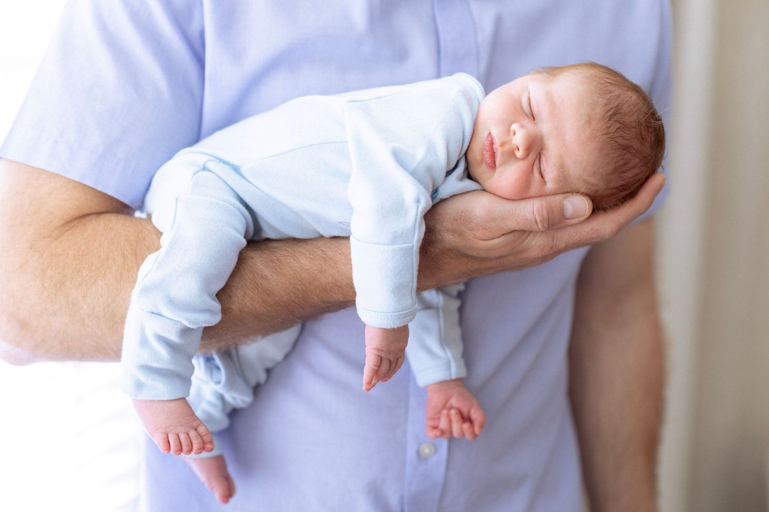A sleeping baby in light blue clothing lies peacefully on white bedding in a series of connected photos.
