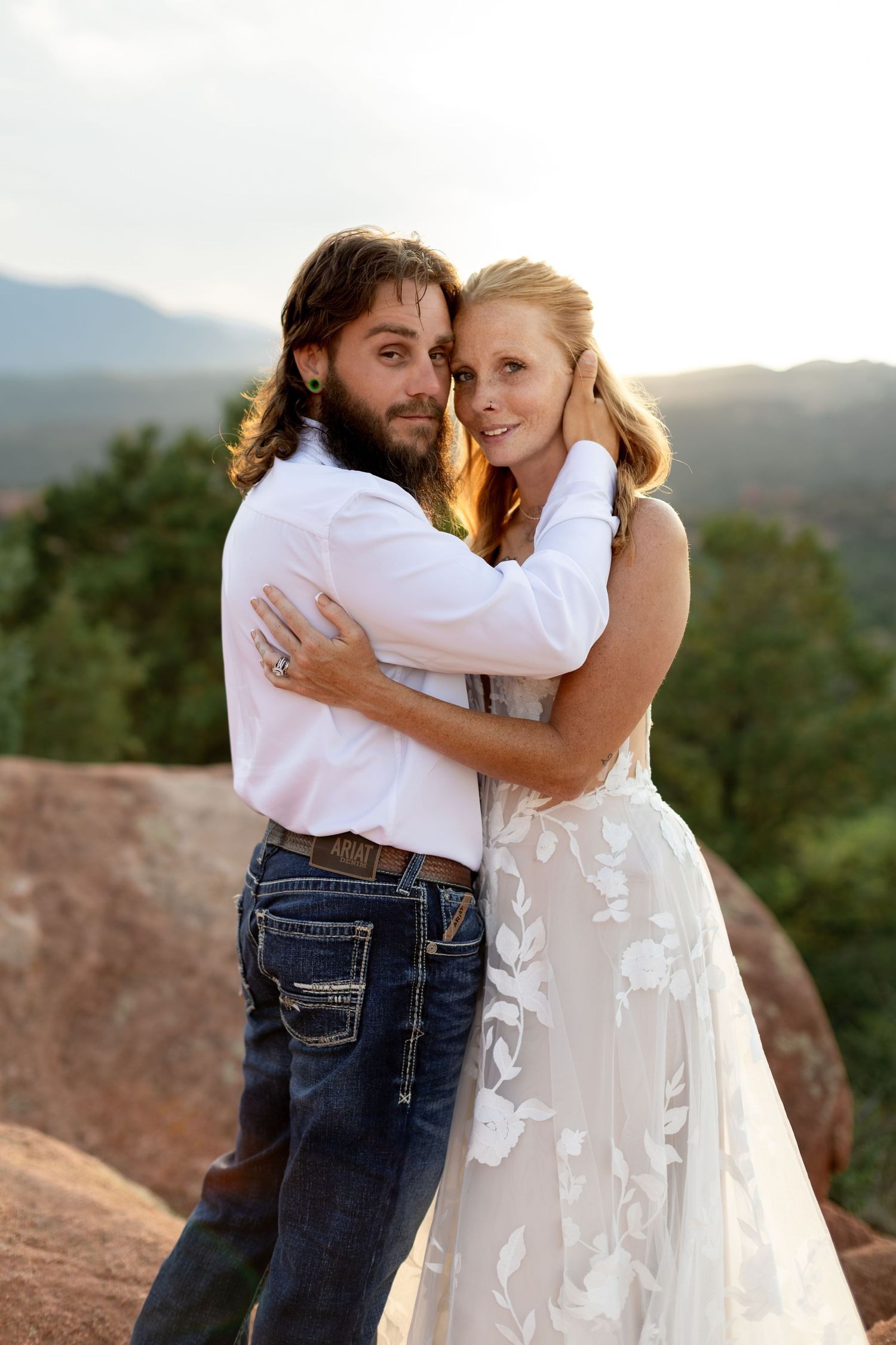 Bride and groom embracing at sunset with mountain views at Garden of the Gods, Colorado wedding.