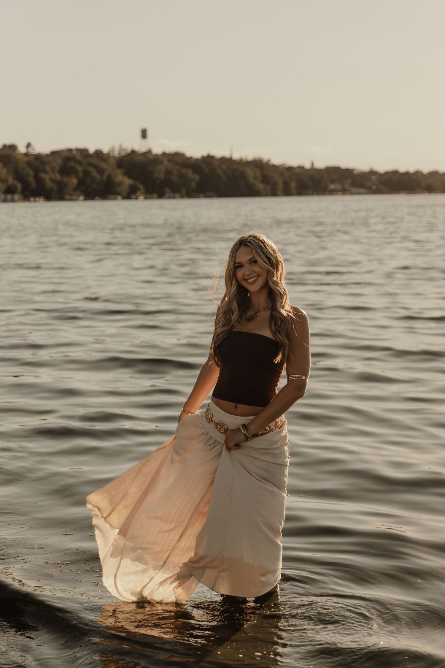 Waterfront portrait with flowing skirt and scenic lake view at sunset.