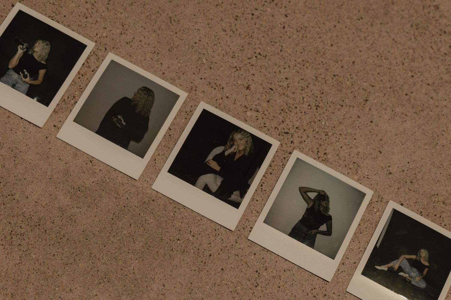 A collection of instant photos laid out in sequence on a beige surface.